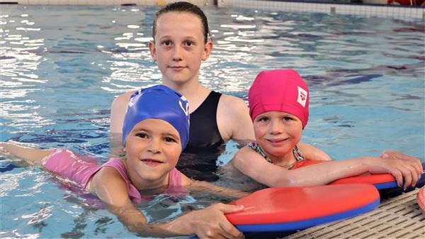 3 jenter smiler i badebassenget